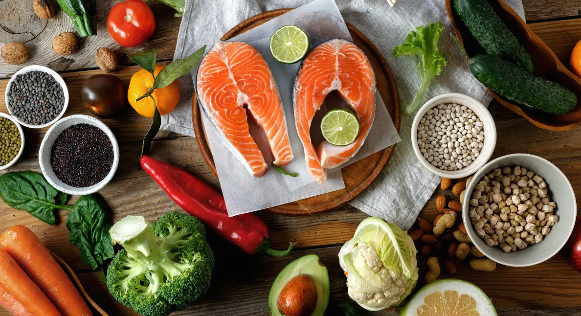 Local product gifts featuring fresh salmon, vegetables, legumes, and citrus arranged beautifully on a rustic wooden table.