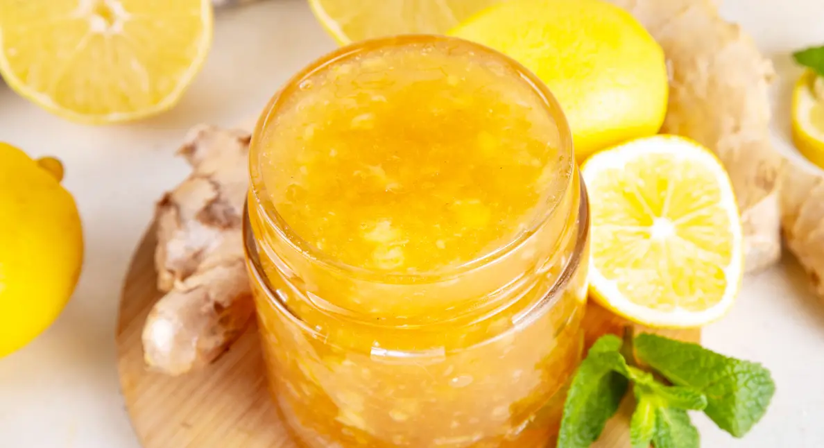 Artisan jam and pickled fruits arranged in glass jars on rustic wooden shelving.