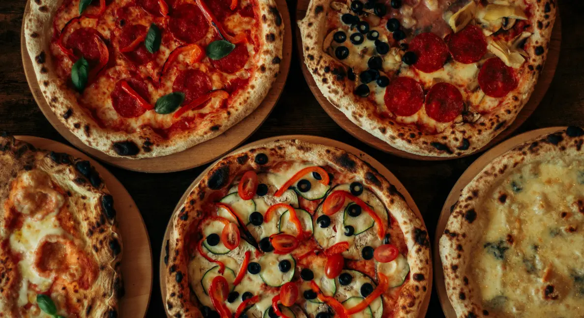 Locally made foods showcased by an assortment of wood-fired pizzas topped with fresh ingredients.