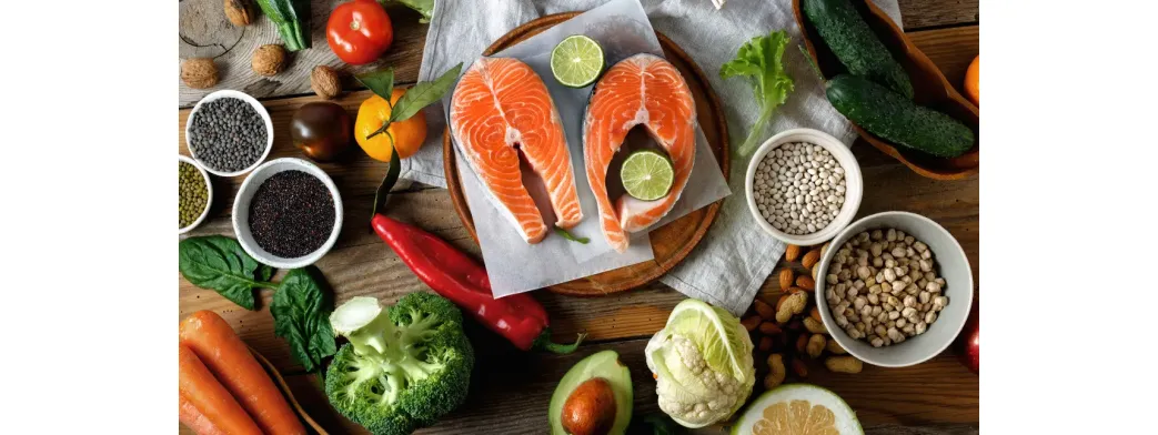 Local product gifts featuring fresh salmon, vegetables, legumes, and citrus arranged beautifully on a rustic wooden table.