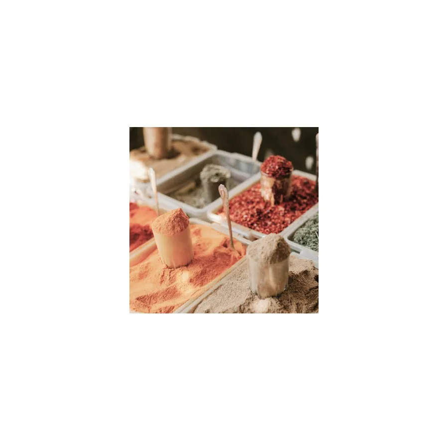Powdered spices in open containers with scoops, featuring a variety of vibrant colors and textures.
